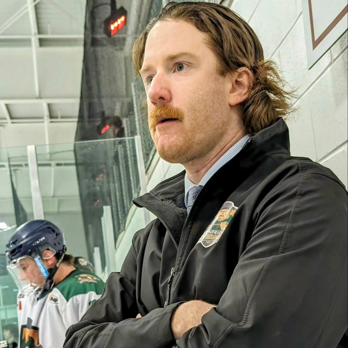 Mike Byrne behind the Rivermen bench in a team jacket